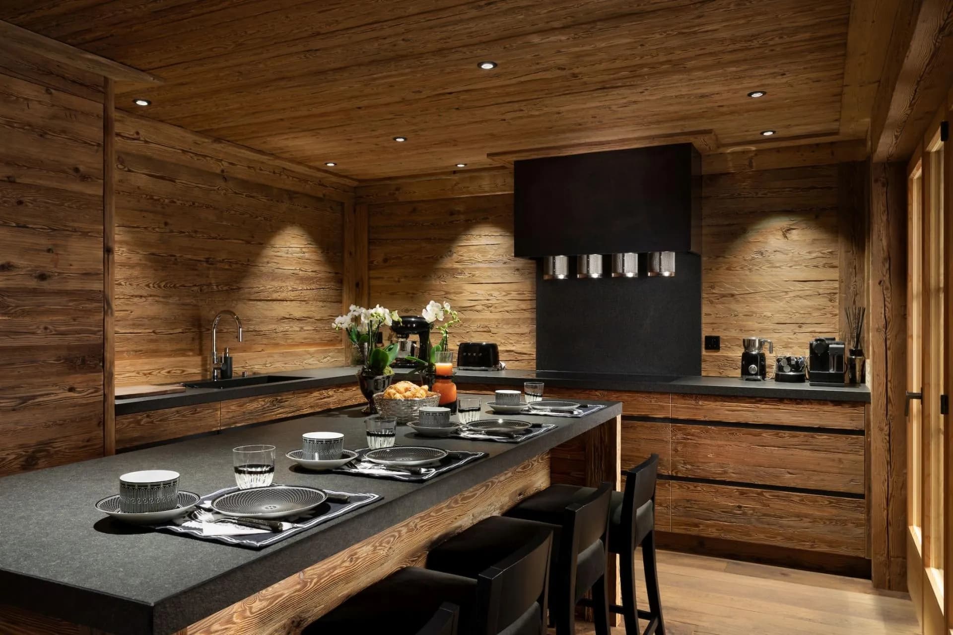 Wood-paneled kitchen with island seating for four and induction cooktop