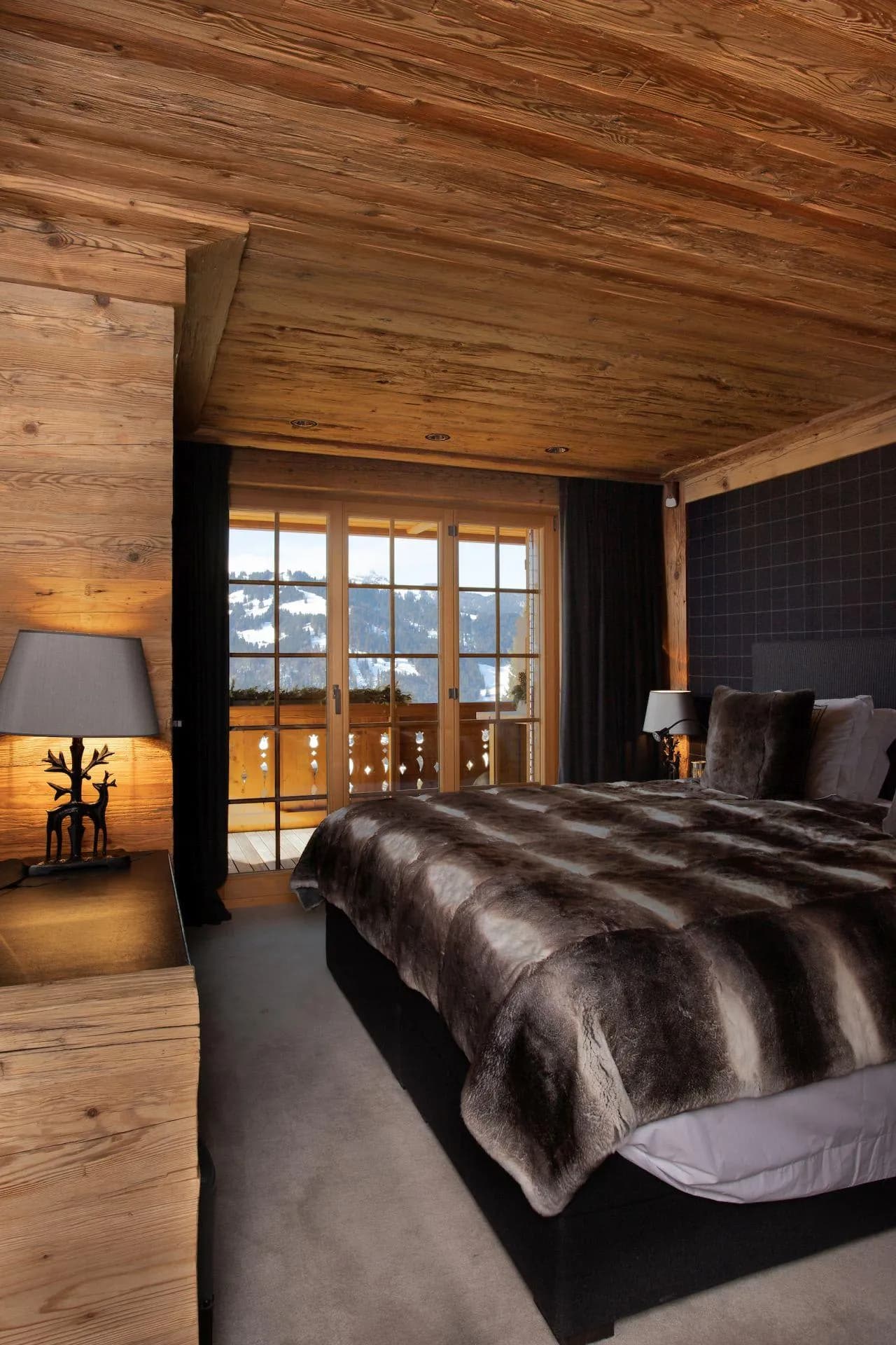 Primary bedroom with king bed, reclaimed wood walls, and balcony access