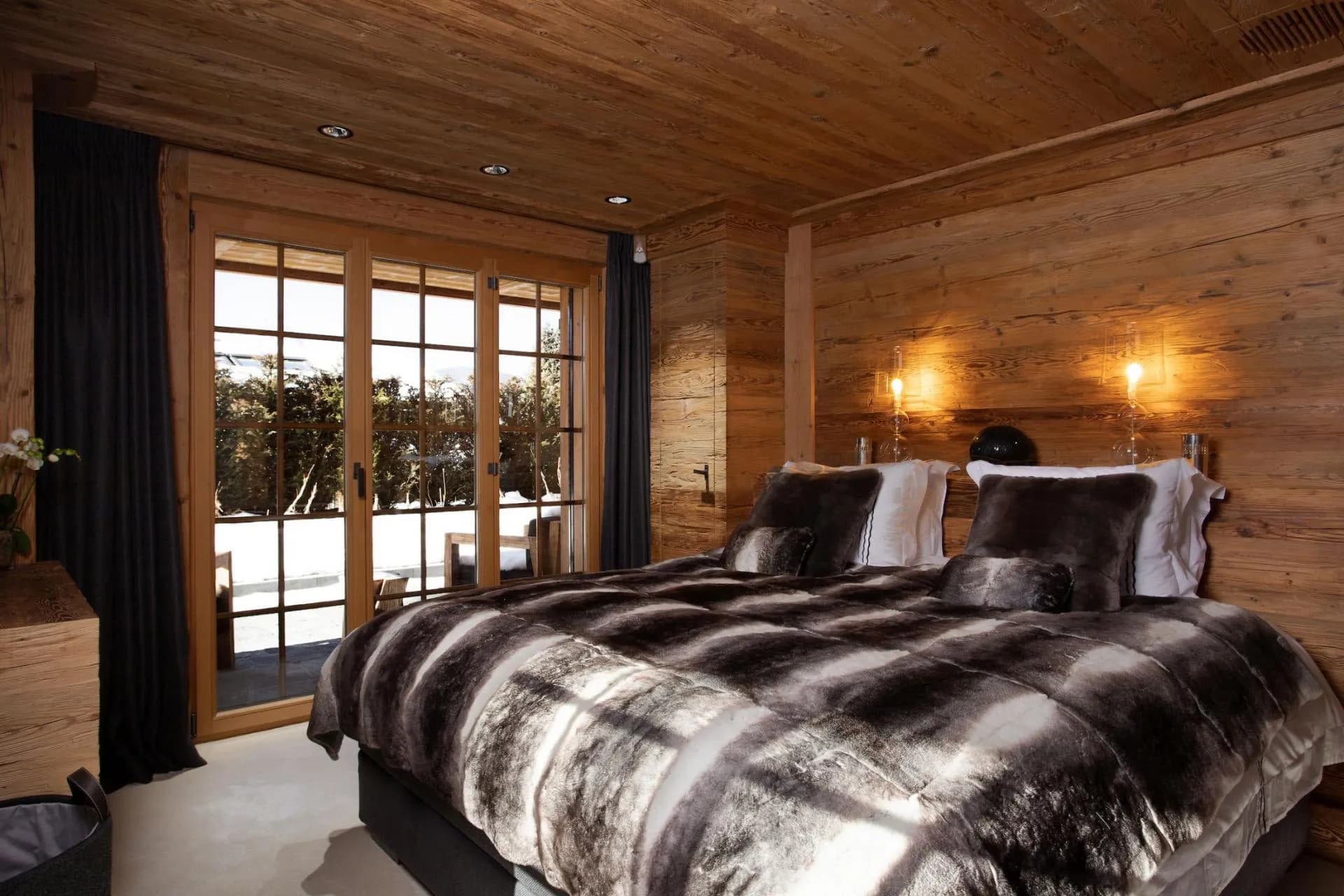 Wood-paneled bedroom with terrace access and floor-to-ceiling blackout curtains