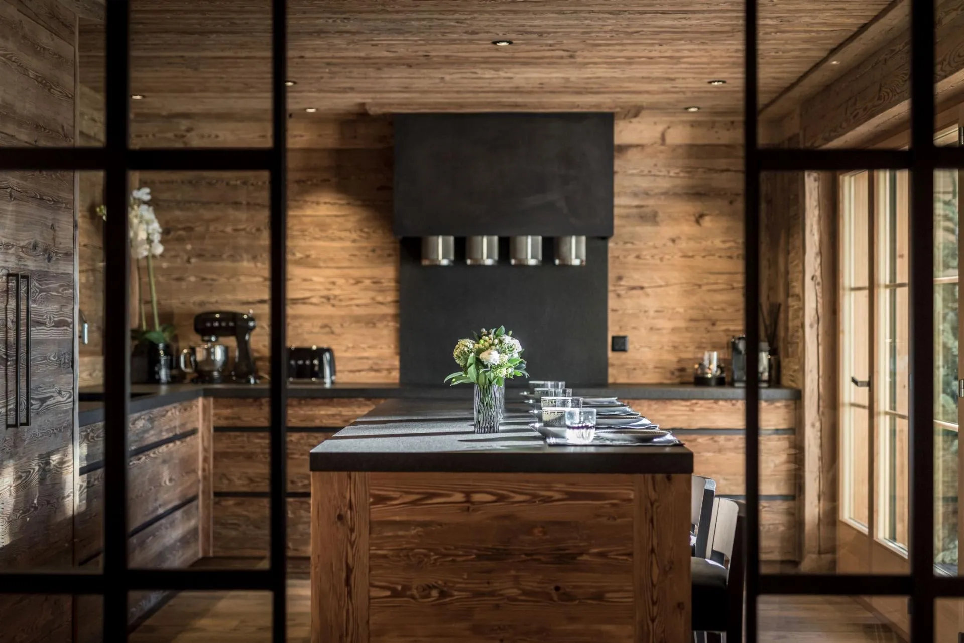 Chef's kitchen with stone island and reclaimed wood paneling