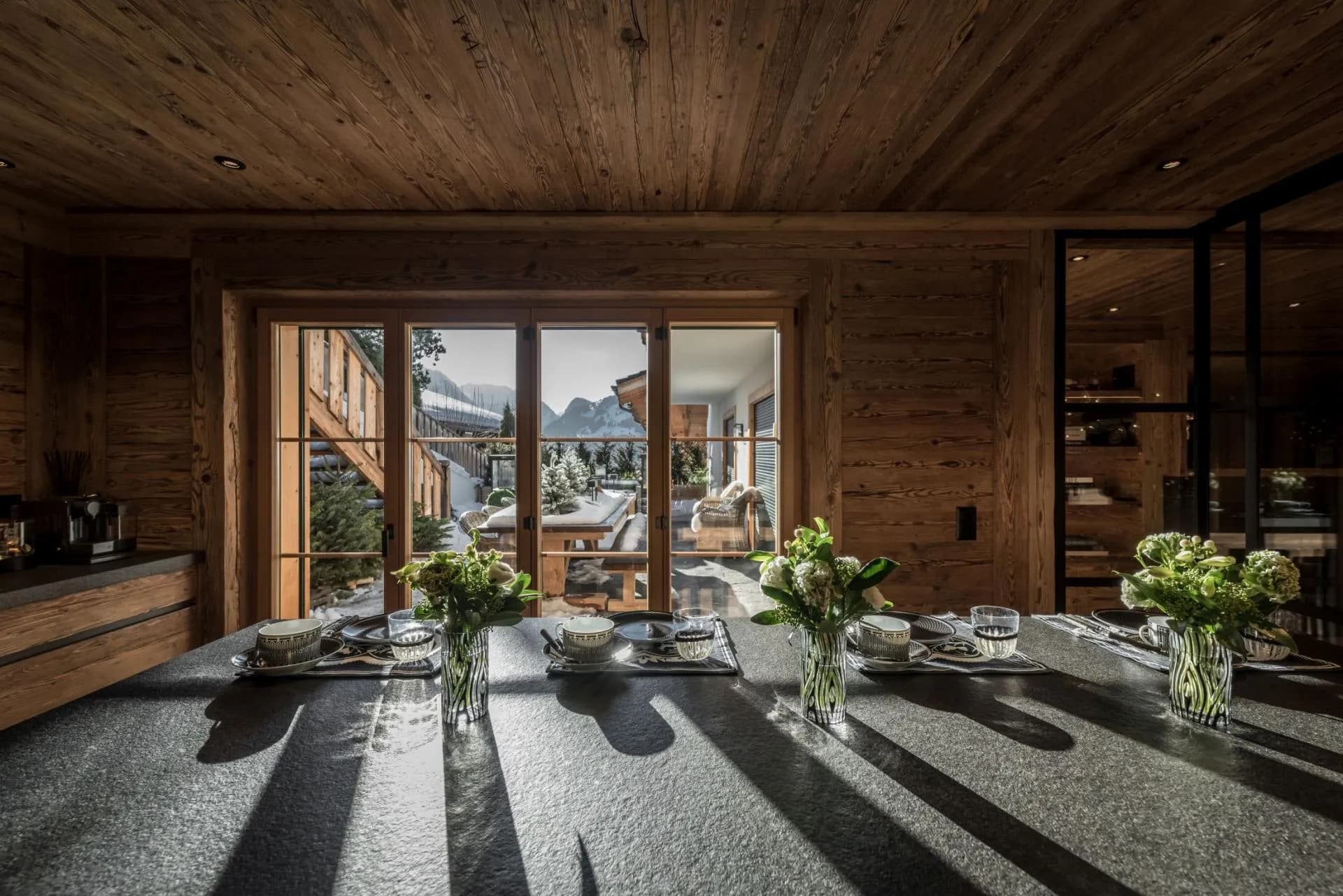 Kitchen island seating with views of the snow-covered terrace and mountains