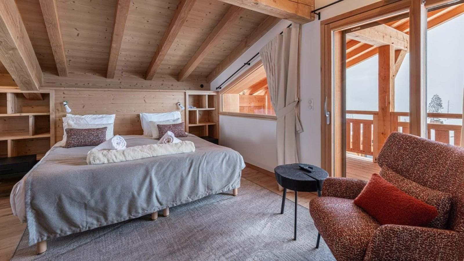 Loft bedroom with king bed, built-in shelving, and private balcony access