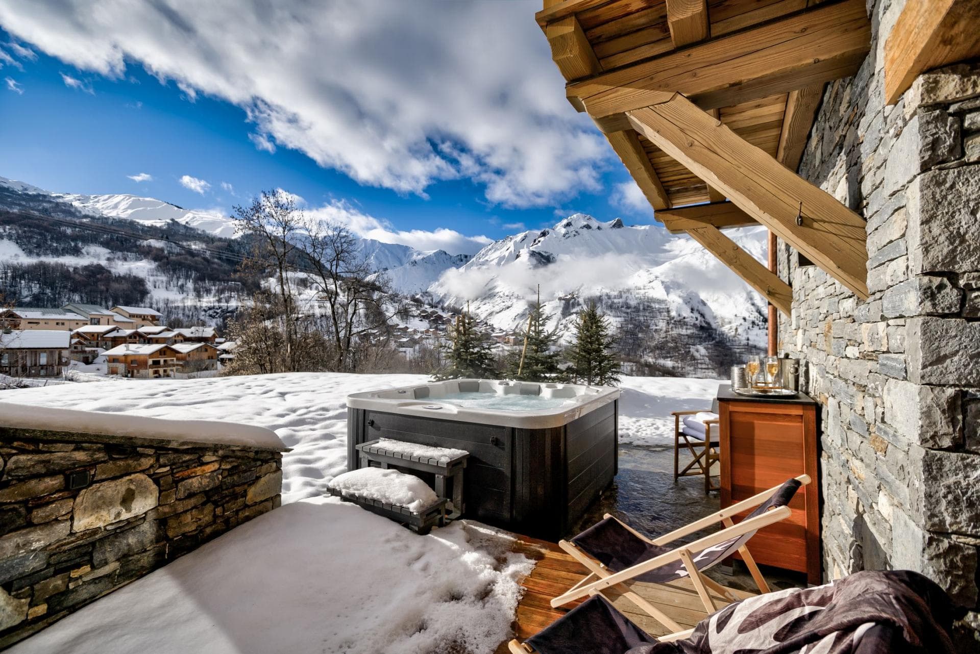Outdoor hot tub with mountain views and adjacent lounge seating