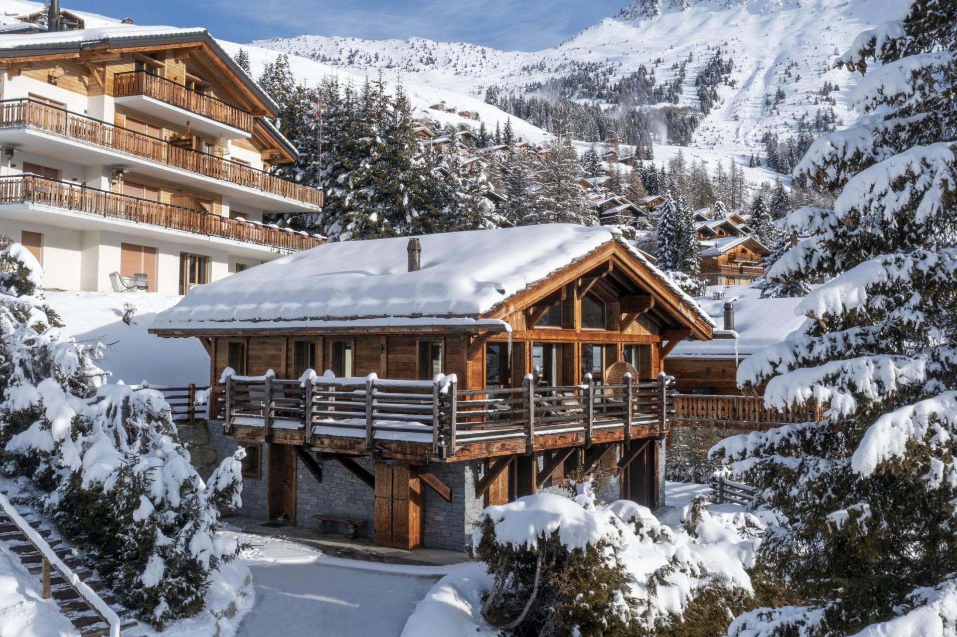 Ski-in chalet exterior with wrap-around balcony and mountain views
