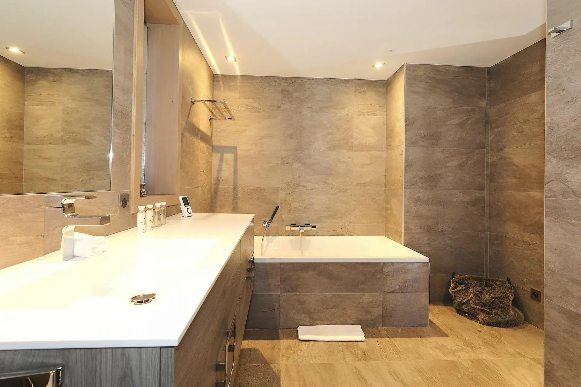 En-suite bathroom with a bathtub and stone tiling