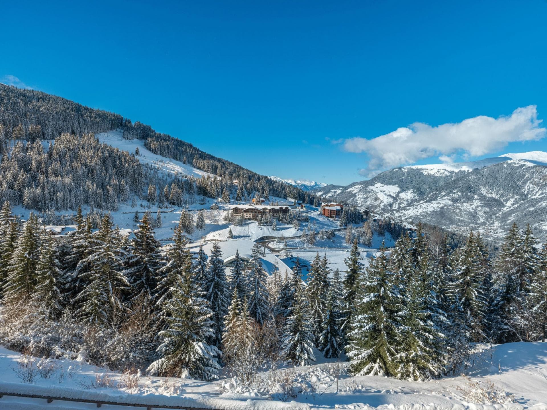 Ski resort view with snowy peaks and alpine forest access