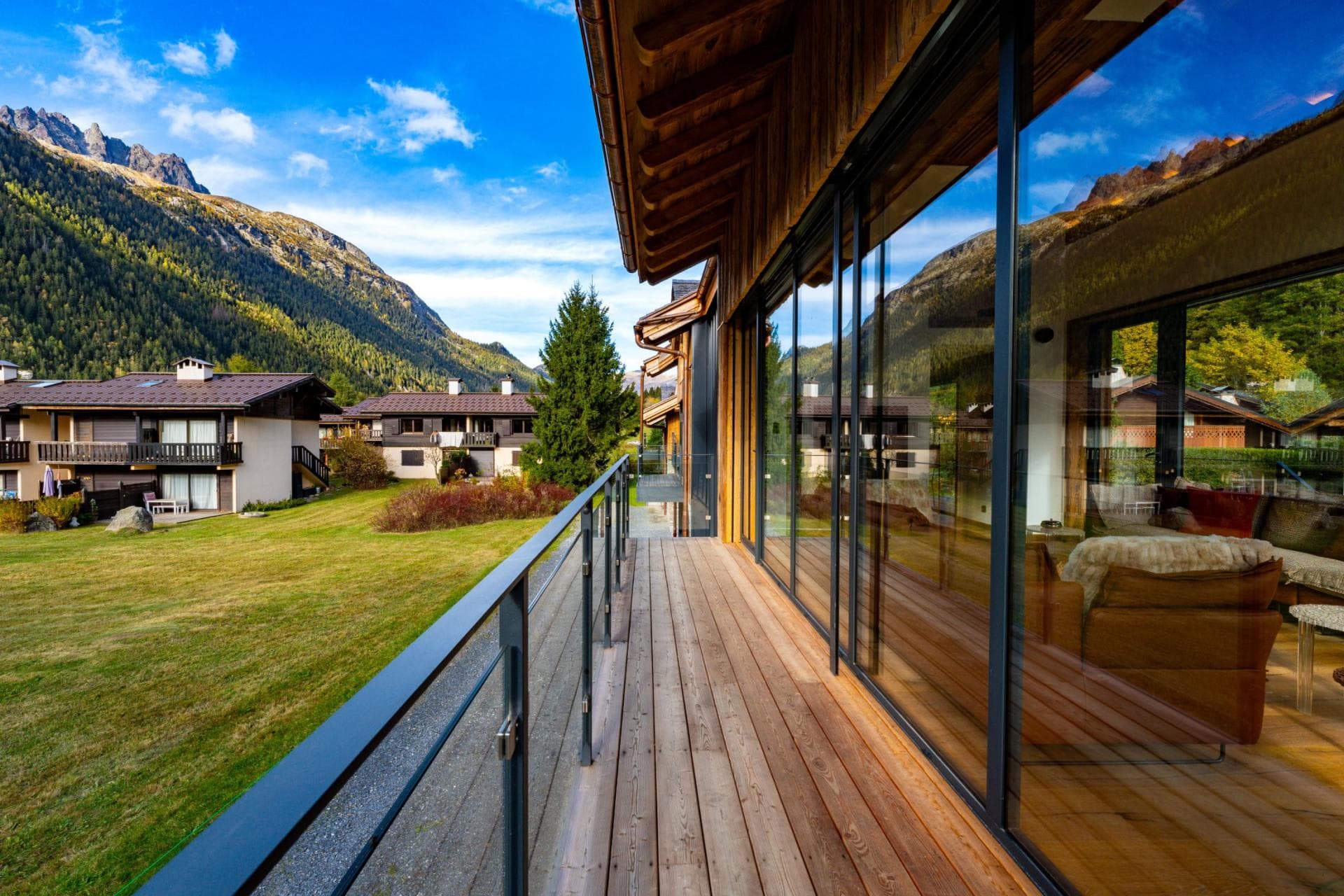 Wooden balcony with floor-to-ceiling glass doors and mountain views