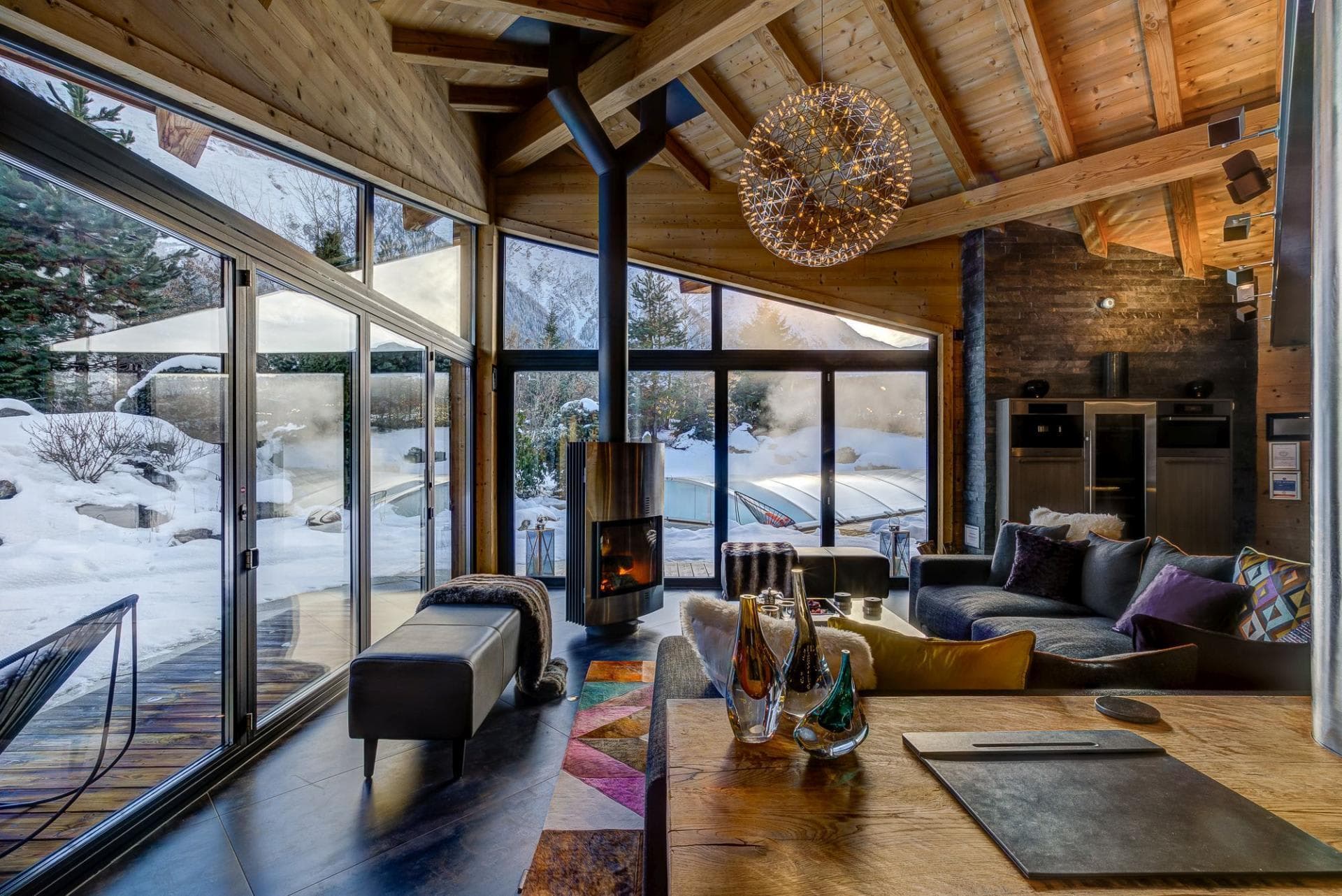 Living area with wood-burning fireplace and floor-to-ceiling mountain views