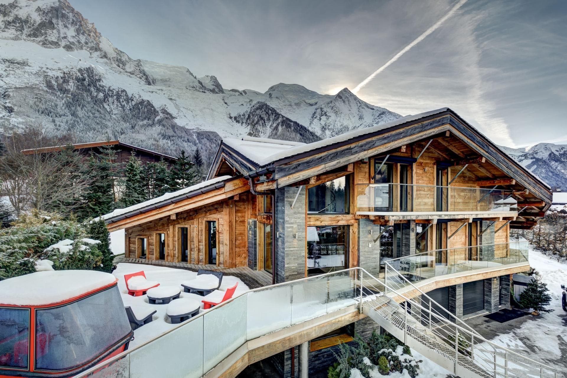 Chalet exterior with mountain views, wrap-around balconies, and outdoor seating area
