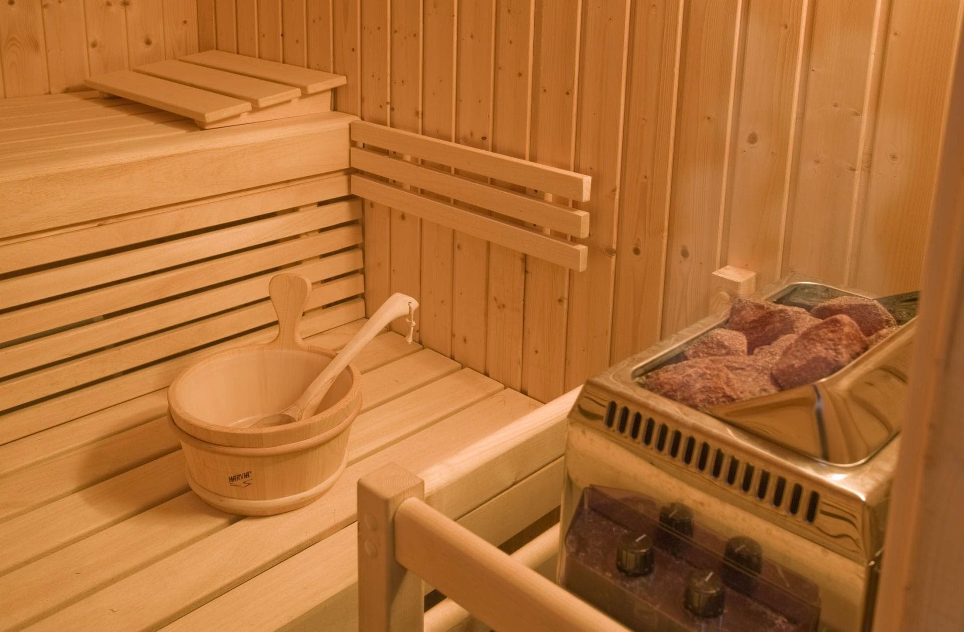 Private sauna with Harvia electric heater and traditional wood bucket