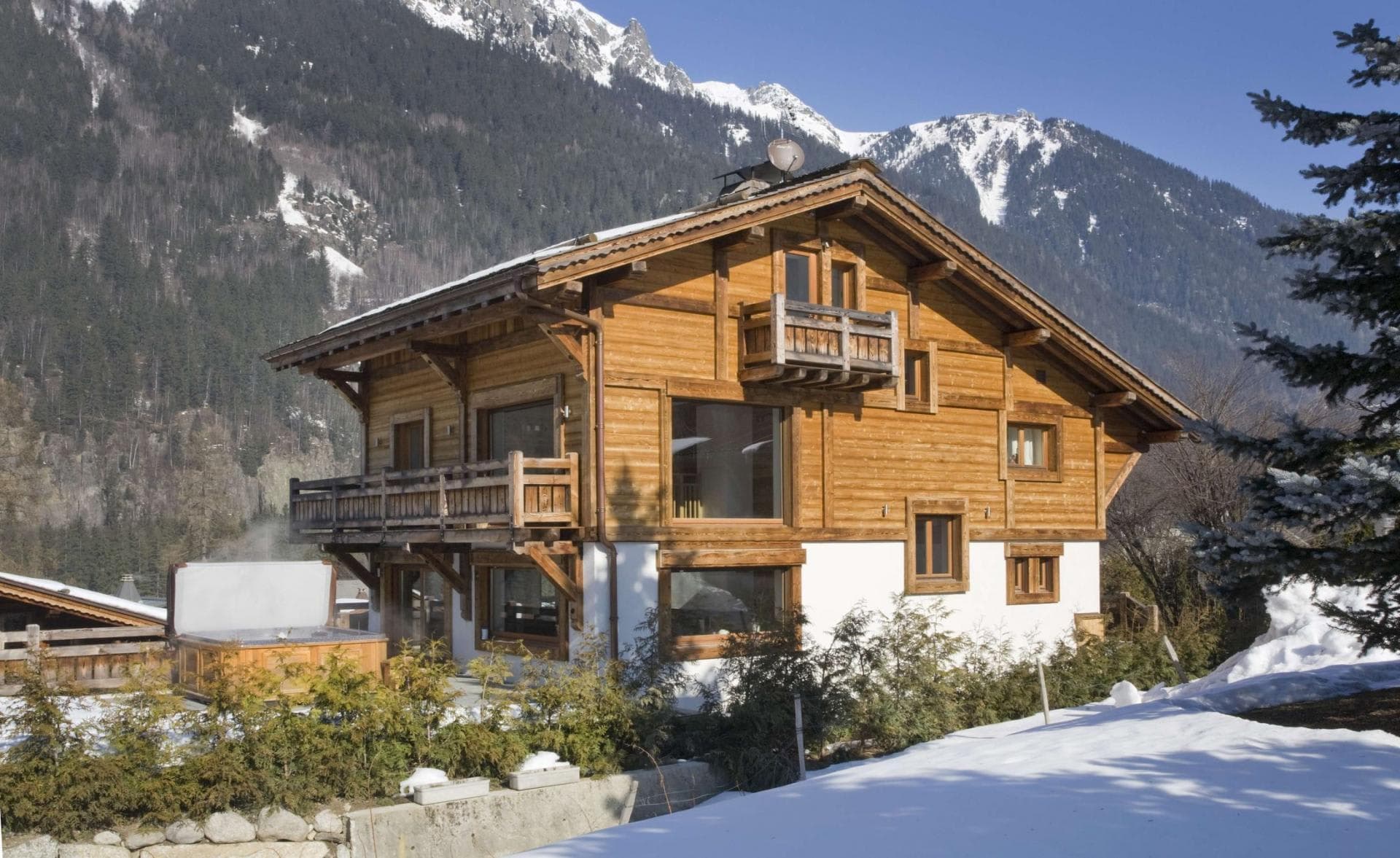 Chalet exterior with ground-floor hot tub and private balconies