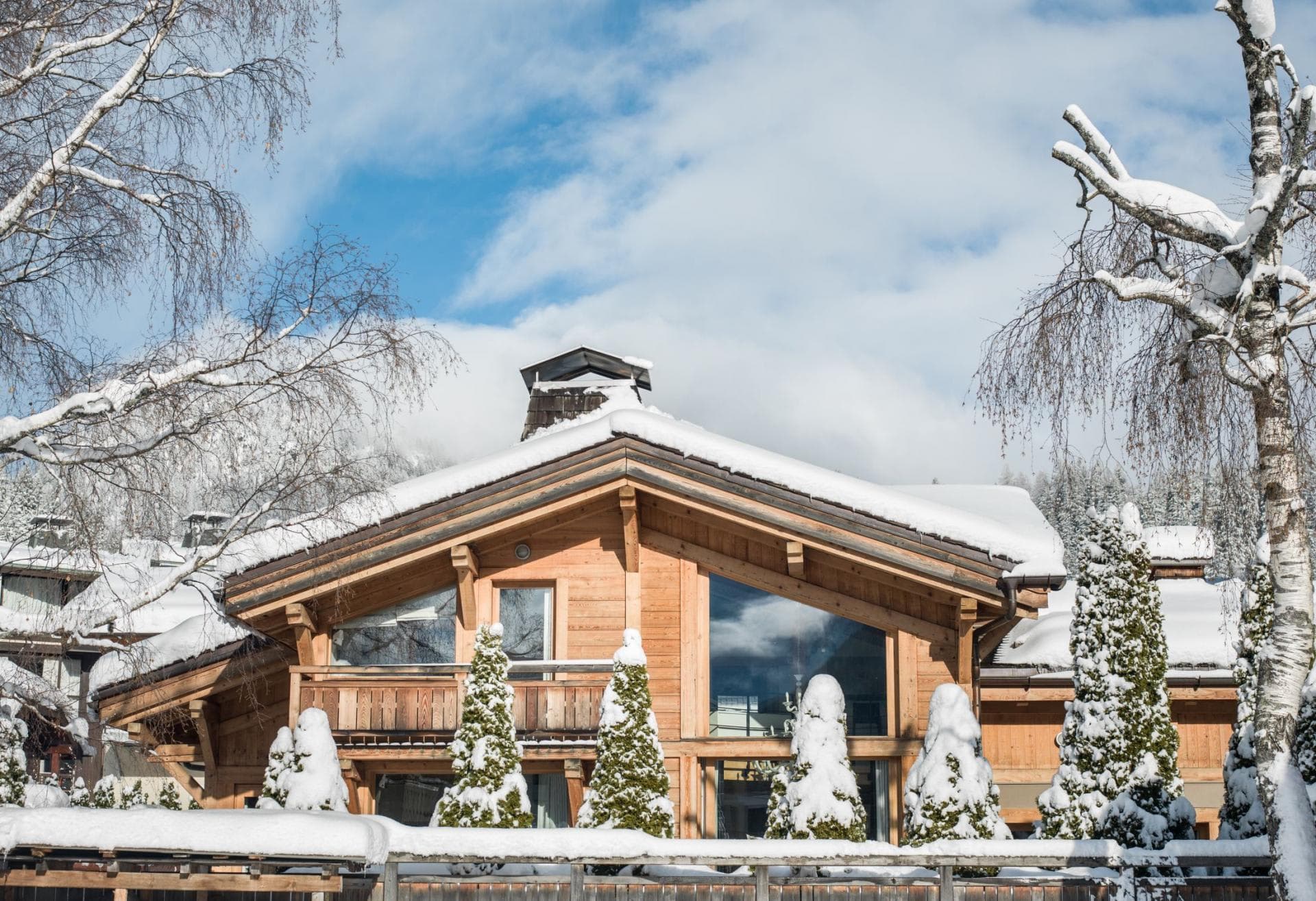 Timber chalet exterior with floor-to-ceiling windows and private balcony