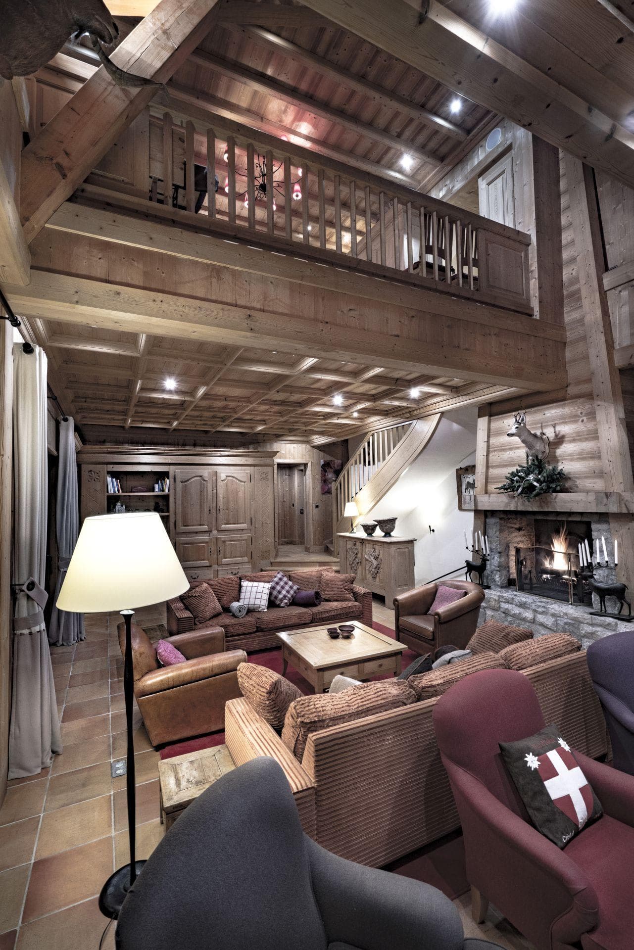 Living area with wood-burning fireplace and mezzanine balcony overlook