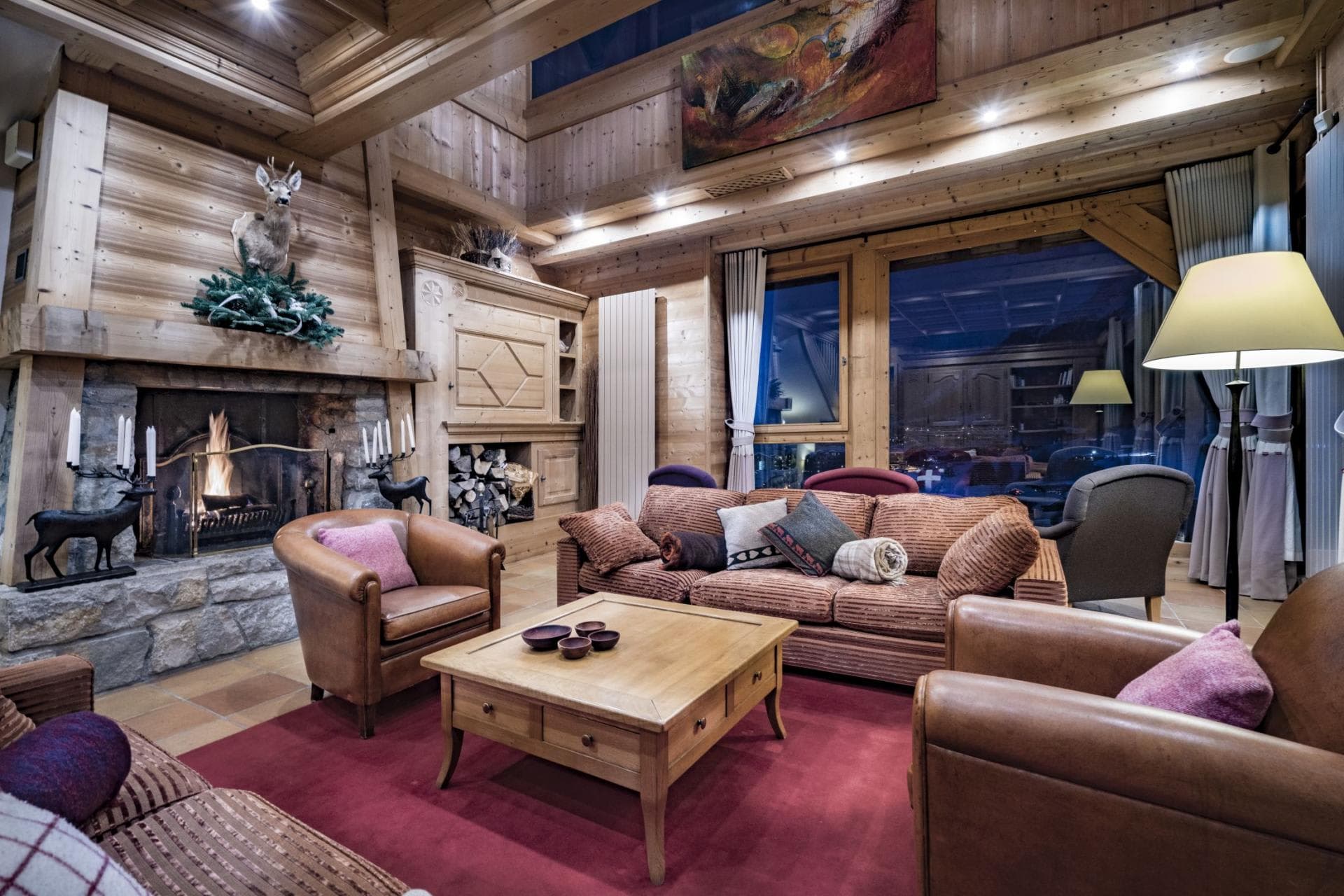 Living area with wood-burning stone fireplace and vaulted timber ceilings