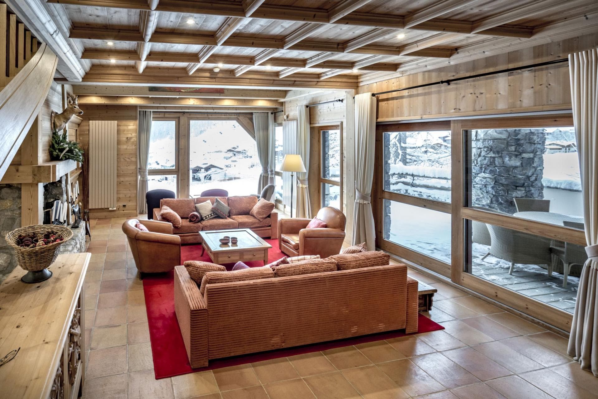 Living area with coffered wood ceiling and floor-to-ceiling snow views