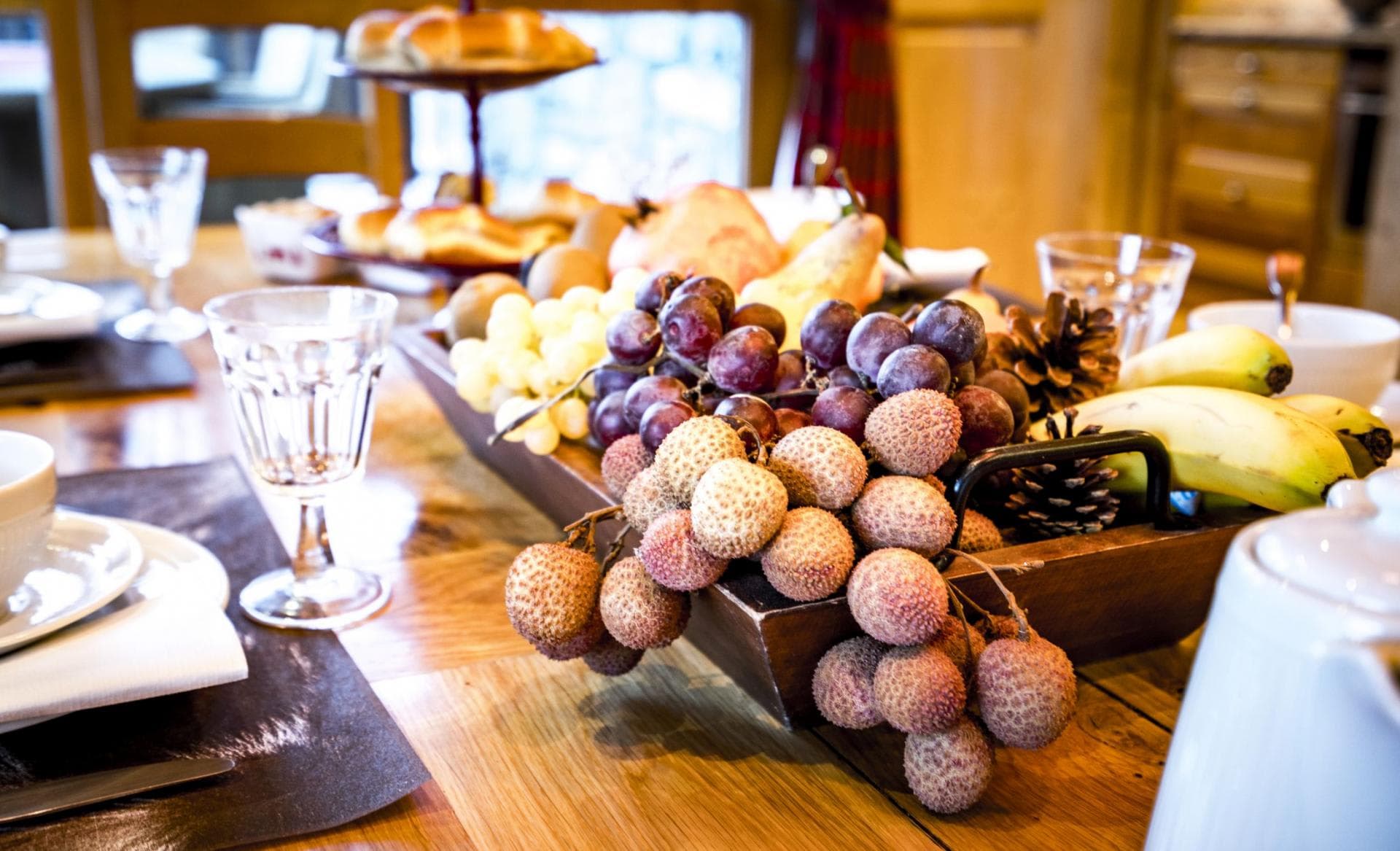 Dining table set for breakfast with fresh fruit and pastries