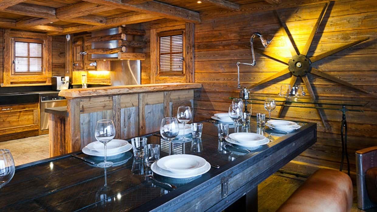 Dining area adjacent to kitchen with reclaimed wood walls and bench seating