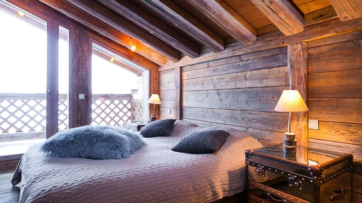 Wood-paneled bedroom with king bed and private balcony access