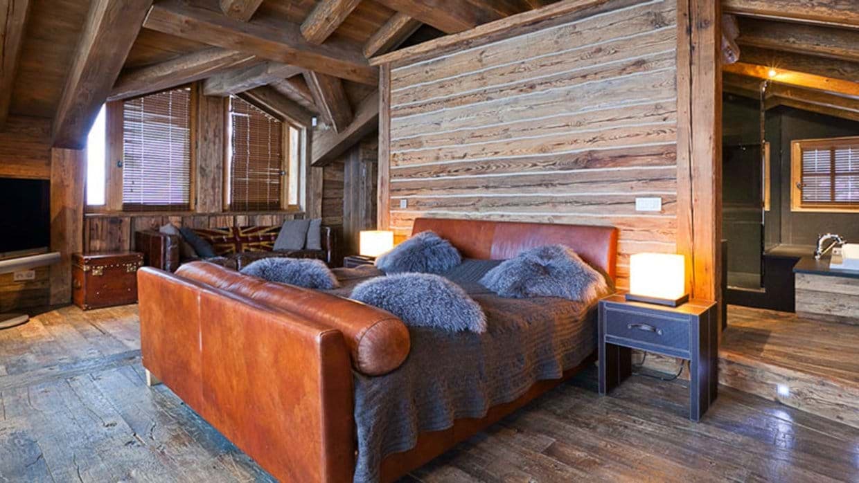 Primary bedroom suite with leather king bed and ensuite bathtub