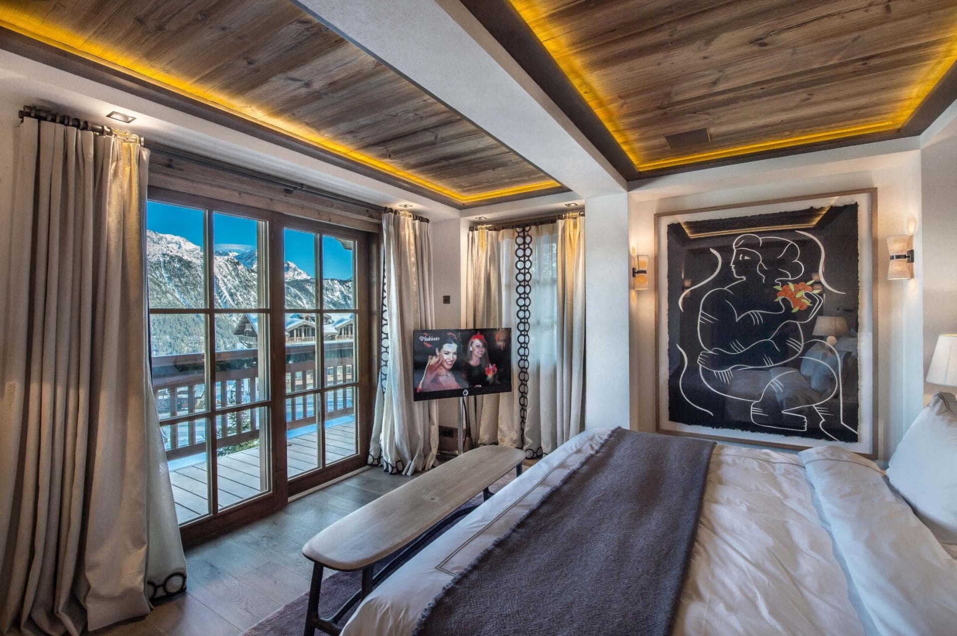 Primary bedroom with mountain views, wood ceiling, heated floors, and ambient lighting