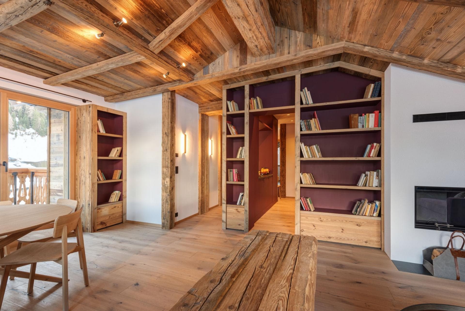 Living area with wood-burning fireplace and floor-to-ceiling library shelving
