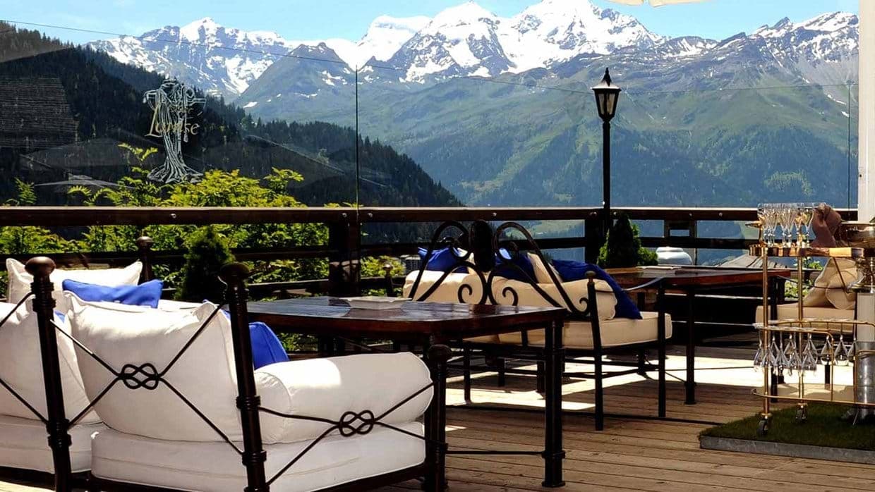 Terrace lounge with cushioned seating and unobstructed mountain views