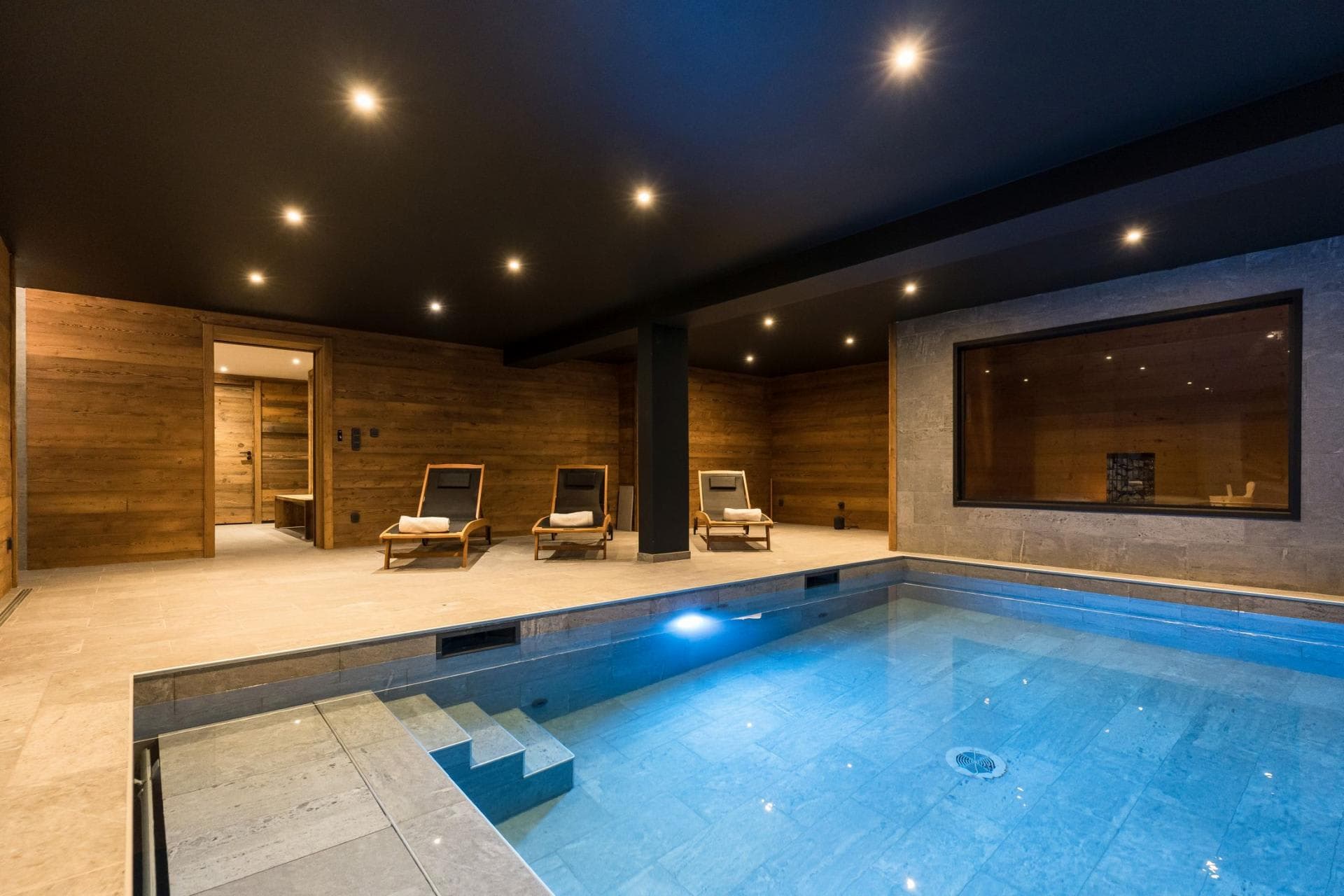 Indoor pool with walk-in steps and lounge seating for three