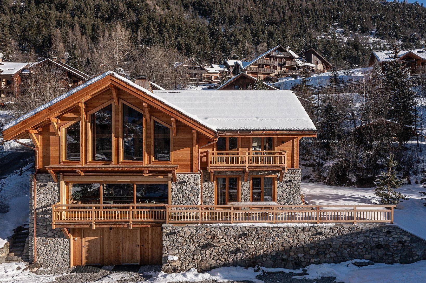 Multi-level chalet with stone foundation, private balconies, and mountain views