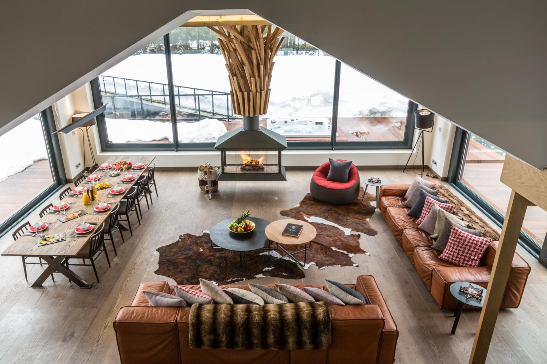 Open living area with central fireplace, dining for 10, and deck with hot tub