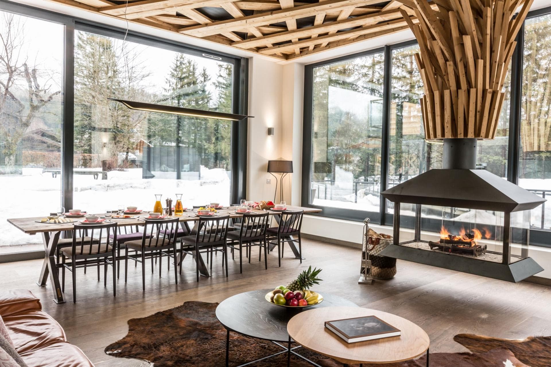 Open-plan dining area with 12-seat table and central wood-burning fireplace