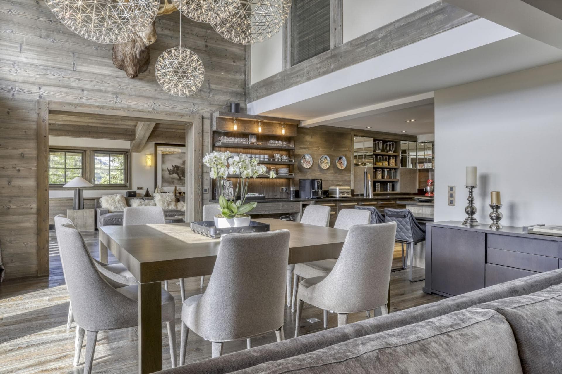 Open-plan dining area seating 8; kitchen and coffee station in background