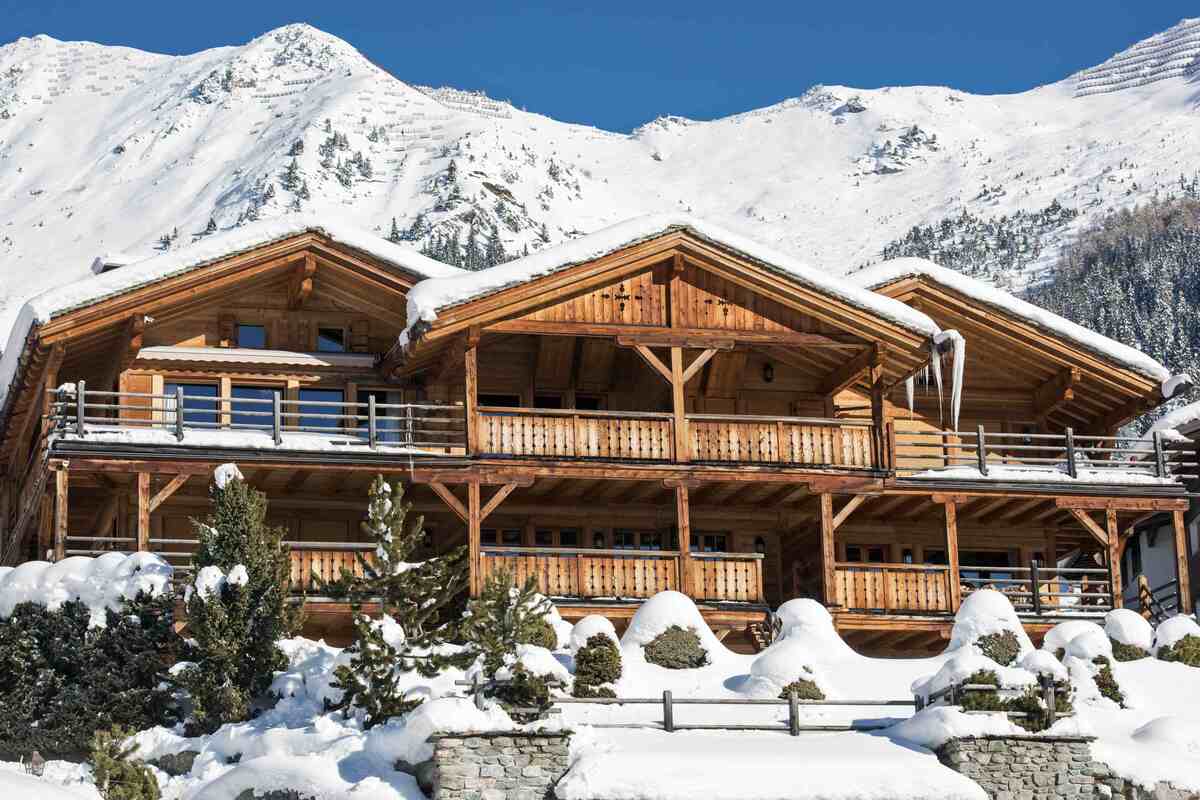 Ski-in chalet exterior with multi-level balconies and mountain views
