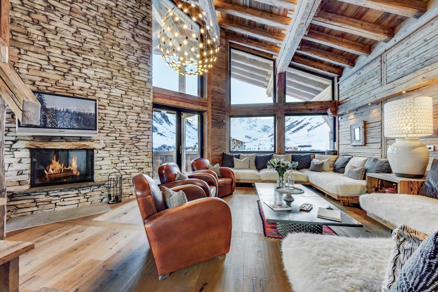 Living area with wood-burning fireplace and floor-to-ceiling mountain views