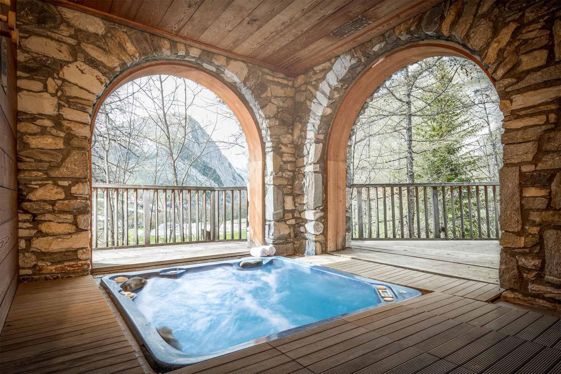 Covered hot tub with mountain views and stone archways