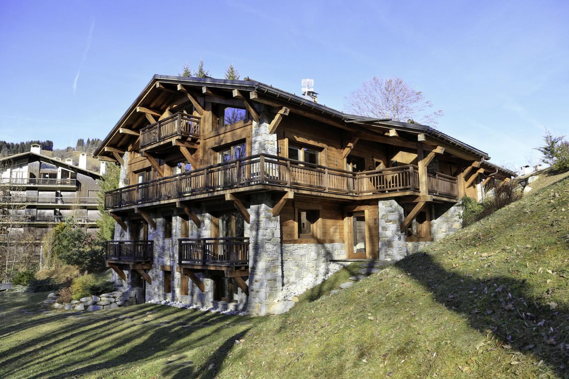 Stone and timber chalet exterior with multi-level wrap-around balconies