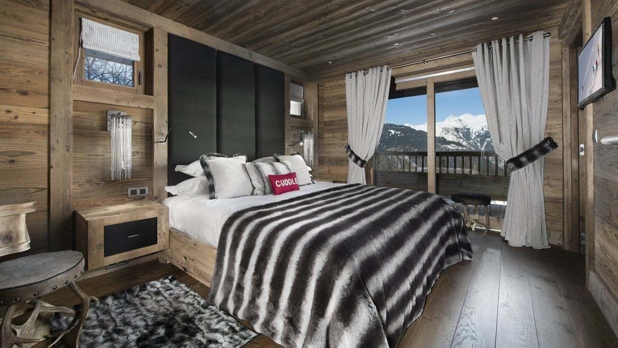 Primary bedroom with king bed and private balcony mountain views