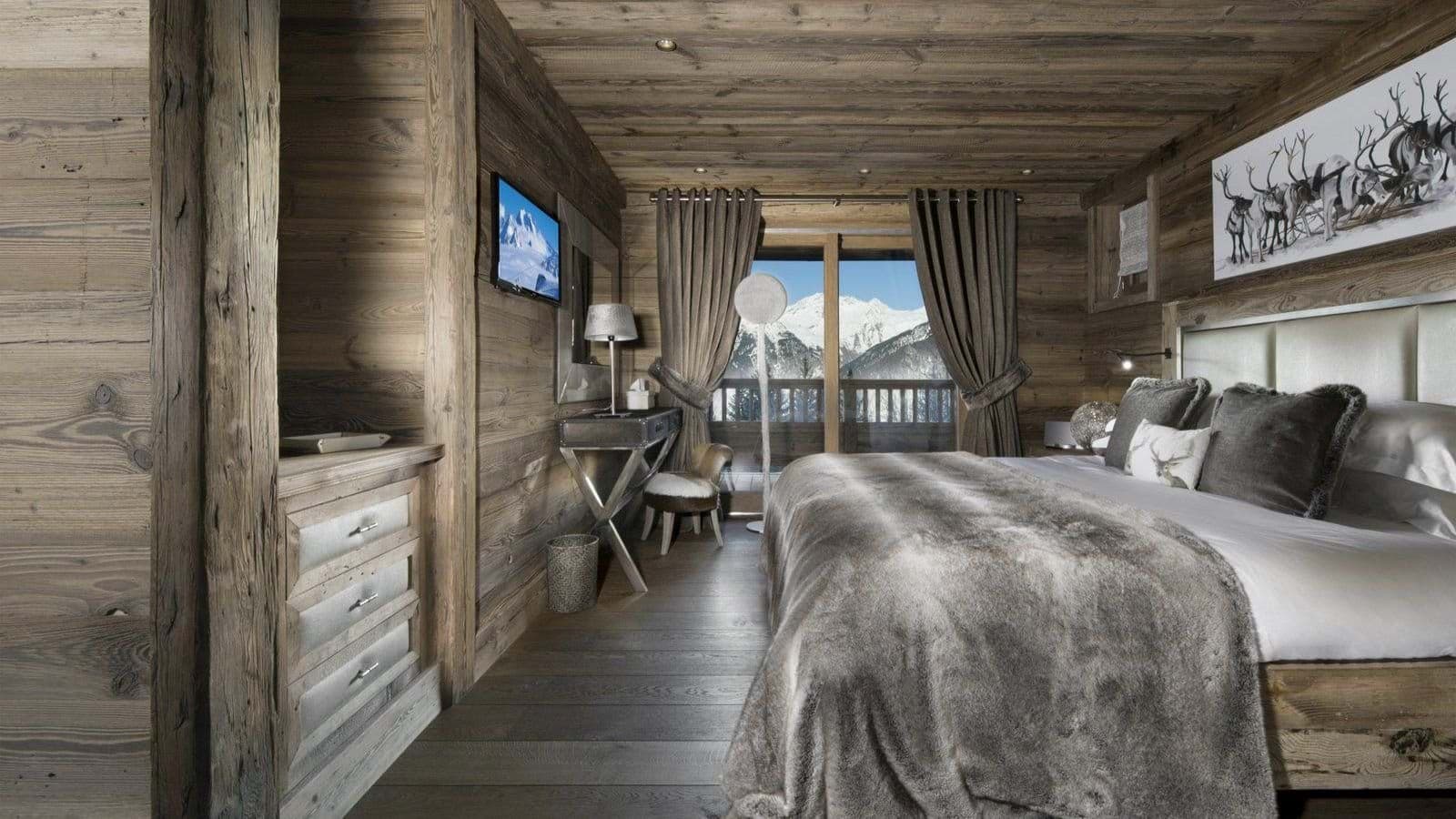 Primary bedroom with king bed, desk, and balcony mountain views