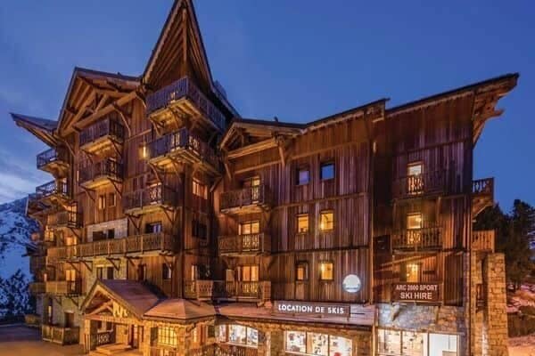 Chalet exterior with ground-floor ski hire shop and private balconies