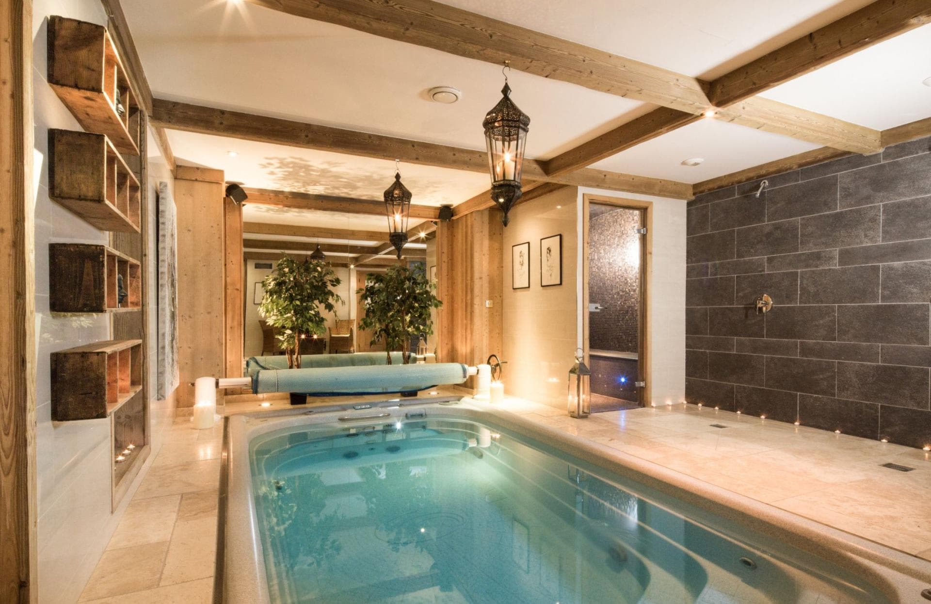 Indoor spa room with resistance pool, steam room, and walk-in rain shower