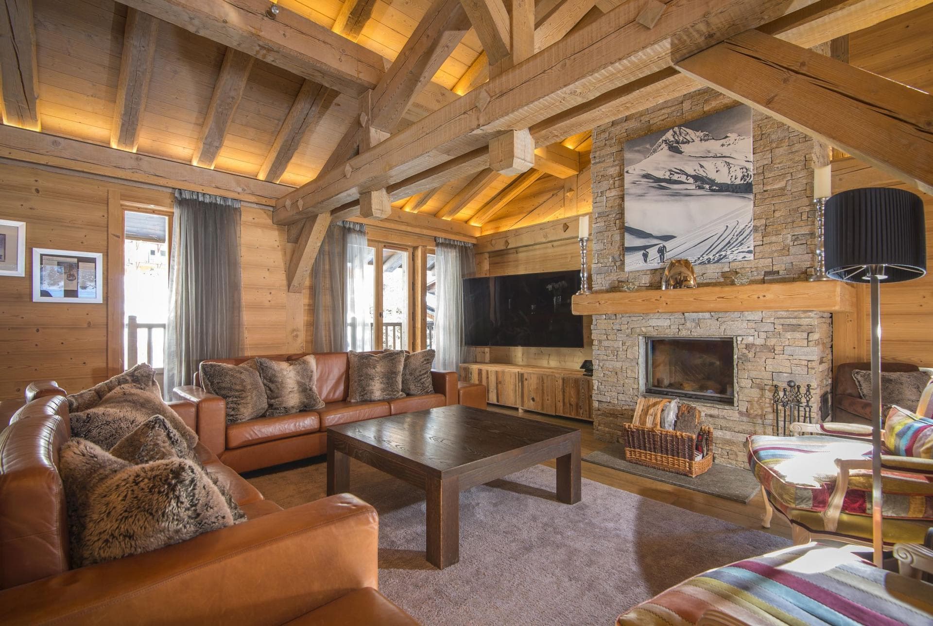 Living area with wood-burning fireplace and vaulted timber beam ceiling