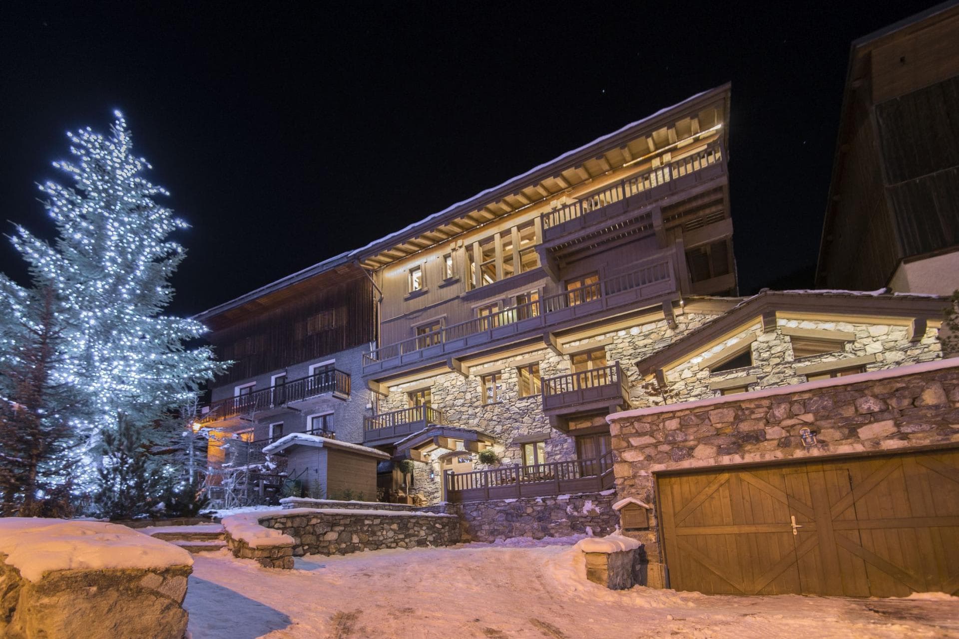 Stone-clad chalet exterior with private garage and heated driveway