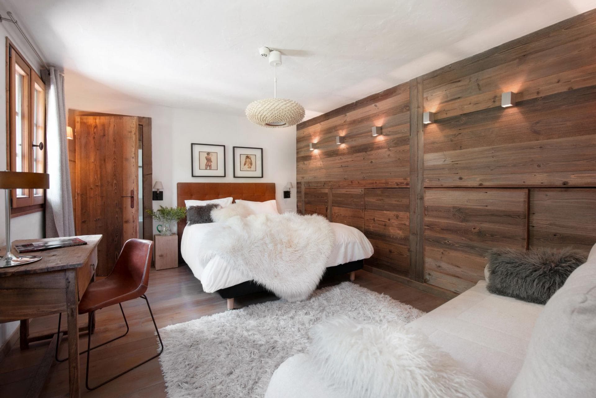 Guest bedroom with queen bed, reclaimed wood paneling, and desk