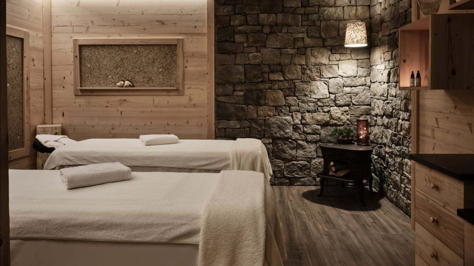 Private spa room with dual massage tables and stone accent wall