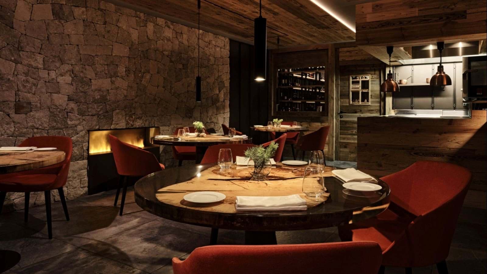 Dining area with live-edge wood tables and stone-surround fireplace