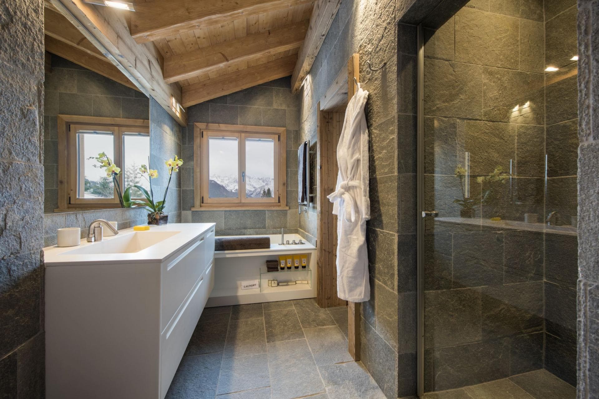 Bathroom with walk-in stone shower and mountain views from soaking tub