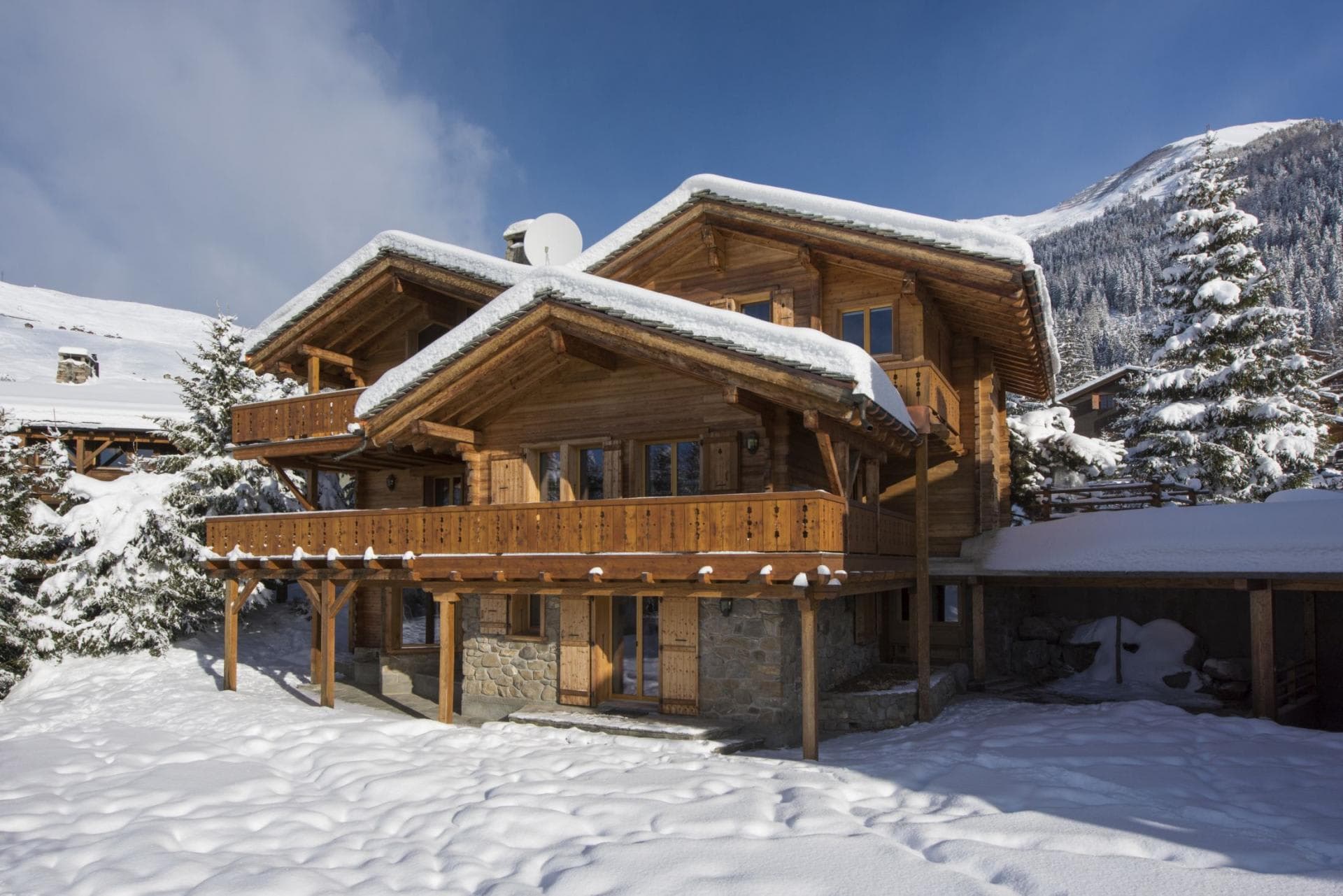 Ski chalet exterior featuring wrap-around balconies and covered carport parking