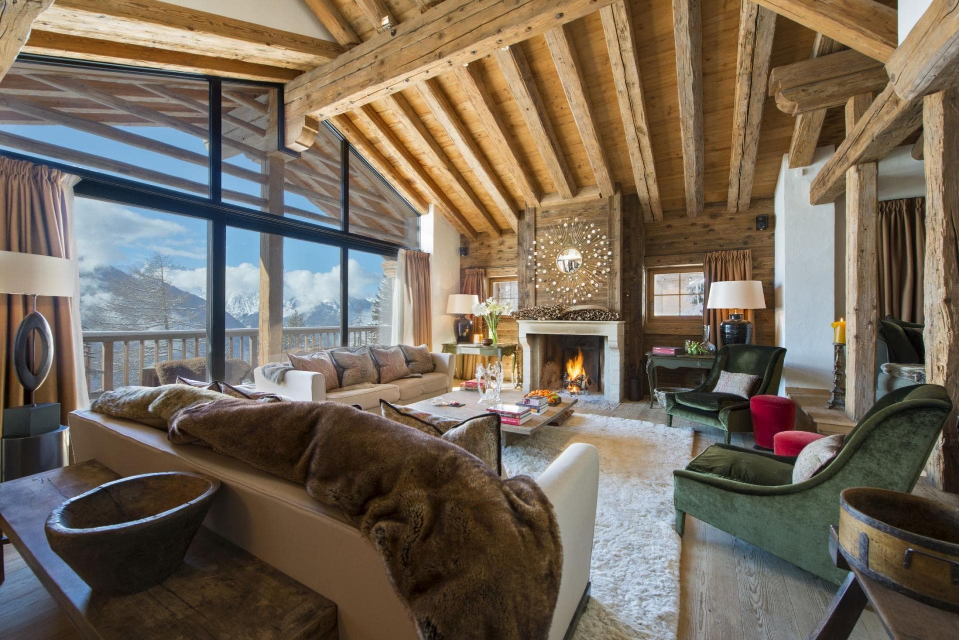 Living area with wood-burning fireplace and floor-to-ceiling mountain views