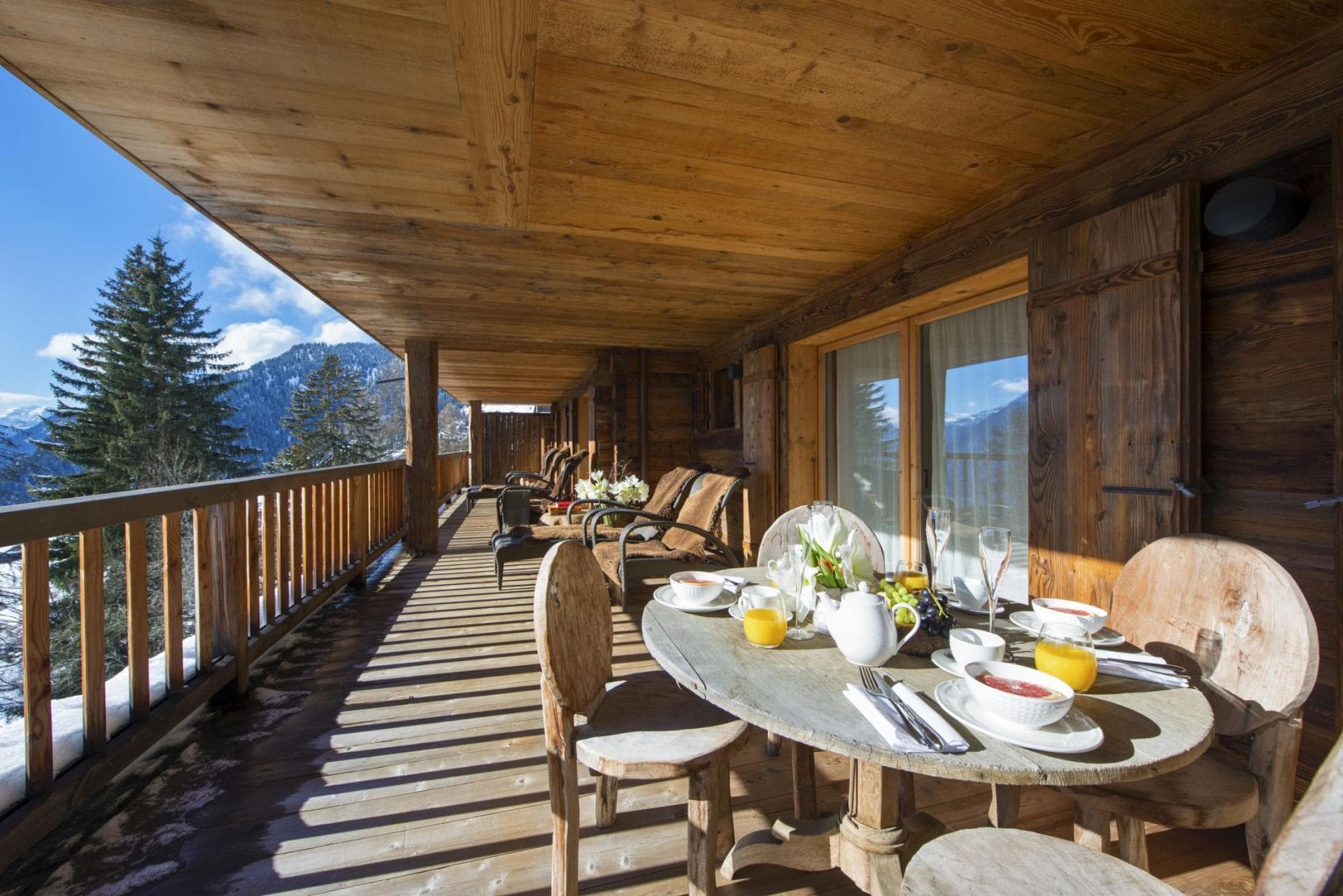Covered balcony with dining table and lounge seating; mountain views