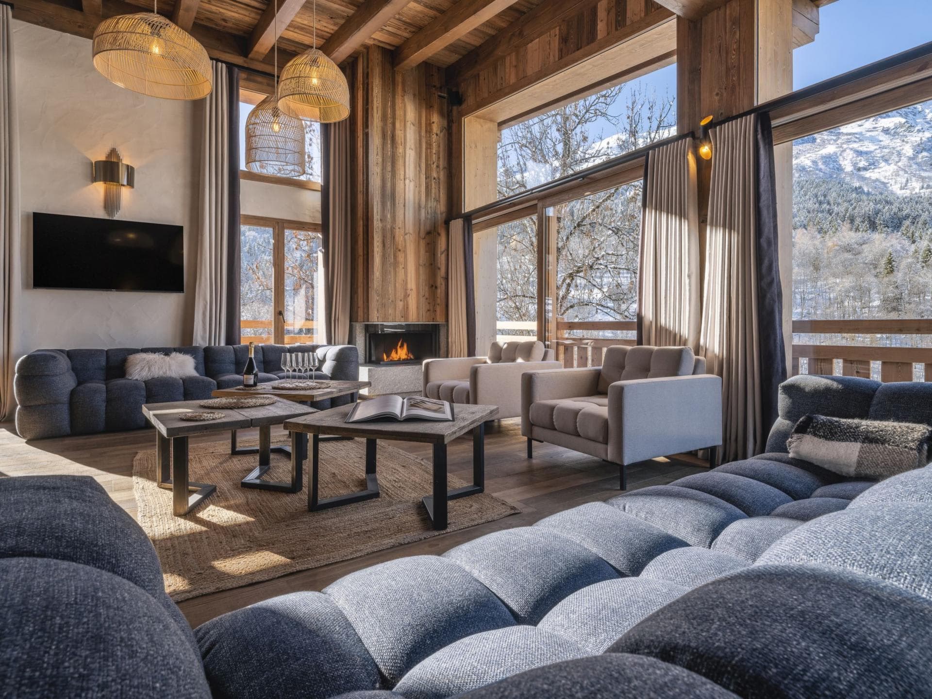 Living area with wood-burning fireplace and floor-to-ceiling mountain views