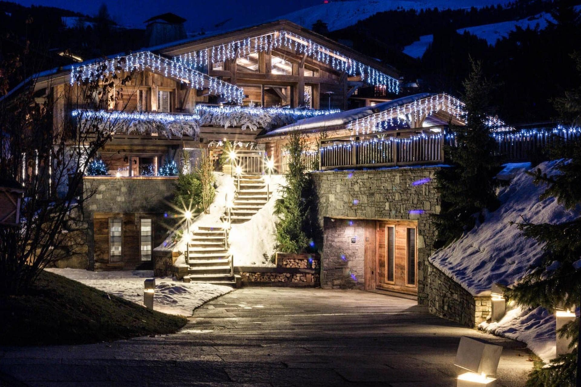 Chalet exterior at night with heated driveway and underground garage